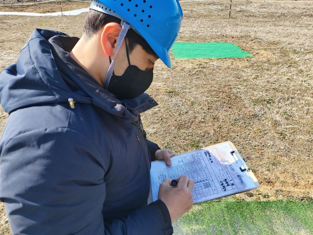 안전모를 착용한 교육생이 비행 전·후 점검표를 기록하는 모습